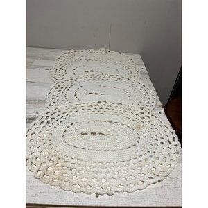 Set of four white crocheted placemats.